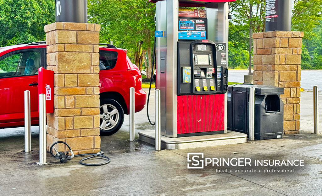 A fuel nozzle that is lying on the ground after a drive away